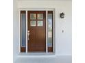 Beautiful front door with sidelights and glass panes with white trim at 6341 Cocoa Ln, Apollo Beach, FL 33572