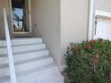 Home's entrance features stairs to the front door and colorful red flowers at the base of the house at 6821 Fairview Ter # 6821, Bradenton, FL 34203