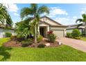 Inviting single-story home featuring lush tropical landscaping and a brick-paved driveway at 6854 Chester Trl, Lakewood Ranch, FL 34202
