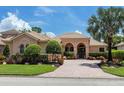 Well maintained single-story home with a tile roof, arched entryway, and a brick driveway at 7037 Brier Creek Ct, Lakewood Ranch, FL 34202