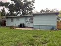 View of the home's backyard, featuring lawn and a light blue exterior at 7555 15Th N St, St Petersburg, FL 33702