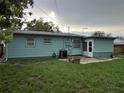 View of the home's backyard, featuring lawn and a light blue exterior at 7555 15Th N St, St Petersburg, FL 33702