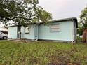 View of home exterior featuring lawn and a light blue facade at 7555 15Th N St, St Petersburg, FL 33702