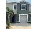 Charming townhome showcasing a one-car garage and a front entrance walkway, with a neatly landscaped yard at 8995 Milestone Dr, Sarasota, FL 34238