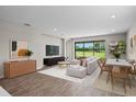 Bright and airy living room featuring wood-look floors, a large sliding glass door and views of the backyard at 9292 Tequila Sunrise Dr, Sarasota, FL 34241
