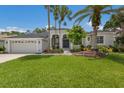Charming single-story home boasts a well-manicured lawn and lush landscaping with beautiful palm trees at 10022 Laurel Valley Avenue Cir, Bradenton, FL 34202