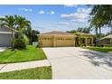 Bright and sunny home exterior with a long driveway, three-car garage, and well-maintained landscaping at 11009 Wildcat Dr, Riverview, FL 33579