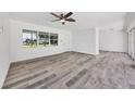 Bright living room with modern floors, large windows, and white brick accent wall at 116 Myakka Dr, Venice, FL 34293