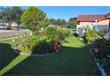 Lush front yard featuring vibrant flower beds, mature trees, and manicured lawn at 1209 Croydonwood Cir, Brandon, FL 33510
