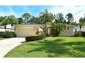 Lovely home with a well-maintained lawn, mature trees, and a paved driveway leading to a two-car garage at 12113 Whistling Way, Lakewood Ranch, FL 34202
