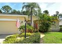 Beautiful single-story home with lush landscaping, green lawn, and an American flag waving at 12113 Whistling Way, Lakewood Ranch, FL 34202