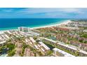 Aerial view of beachfront condos near a beautiful sandy beach and blue ocean at 1257 S Portofino Dr # 306, Sarasota, FL 34242
