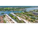 Aerial view of waterfront condos on a canal, with a community tennis court and city views at 1257 S Portofino Dr # 306, Sarasota, FL 34242