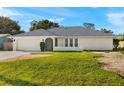 Charming single-story home featuring a well-maintained lawn and an attached two-car garage at 19897 Midway Blvd, Port Charlotte, FL 33948