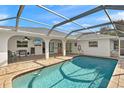Screened-in pool area featuring stone pavers, and clear blue water at 19897 Midway Blvd, Port Charlotte, FL 33948