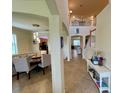 Inviting foyer with an elegant staircase, tile flooring, and a clear view into the dining and living areas at 20940 Valore Ct, Venice, FL 34293