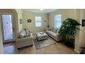 Cozy living room features neutral furniture, natural light, and tile floors, creating a welcoming space at 20940 Valore Ct, Venice, FL 34293