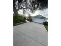 Long concrete driveway leading to a two-car garage on a well-maintained property at 2200 E Village Ct, Venice, FL 34293