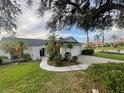 Charming single-story home with lush landscaping, palm trees, and a well-maintained lawn at 2200 E Village Ct, Venice, FL 34293