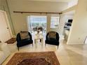 Open living space with tile floors, neutral walls, stylish chairs, and view to lanai at 2200 E Village Ct, Venice, FL 34293