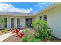 Inviting front entrance with double doors, decorative plants and flowers surrounding the walkway to home at 2512 Jamaica St, Sarasota, FL 34231