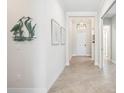 Inviting hallway with neutral paint, crown molding, and decorative wall art at 25143 Spartina Dr, Venice, FL 34293