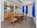 Bright dining area featuring modern lighting, wooden table and chairs, complemented by vivid blue curtains at 305 Chauncey Ave, Bradenton, FL 34208
