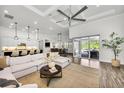 Bright living area with hardwood floors, neutral decor, open floor plan, and modern ceiling fan at 3379 Chestertown Loop, Bradenton, FL 34211