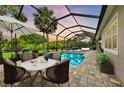 Outdoor living space showcasing a screened-in pool, sun loungers, and a dining area for upscale entertaining at 3379 Chestertown Loop, Bradenton, FL 34211