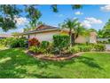 Landscaped front yard featuring lush tropical plants and shrubs creating a welcoming entrance to the home at 3530 Wilkinson Woods Dr # 14, Sarasota, FL 34231