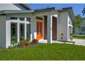 Stylish front entry showcasing a vibrant orange door with a contemporary design at 3636 Mineola, Sarasota, FL 34239