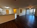 Open-concept living room with hardwood floors, fan and sliding glass doors to screened porch at 4002 Crockers Lake Blvd # 11, Sarasota, FL 34238