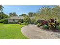 Well-maintained home features lush landscaping and a brick driveway at 4761 Pine Harrier Dr, Sarasota, FL 34231