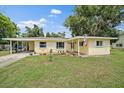 Charming single-story home with yellow siding, white shutters, and a well-manicured lawn at 5350 Barbarossa Ave, Sarasota, FL 34235