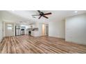 Spacious living room featuring open floor plan with wood flooring, ceiling fan, and stainless steel appliances at 5438 Potter St, Sarasota, FL 34232