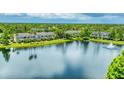 Overhead angle of a lakefront property nestled among trees, providing a tranquil view at 8827 Manor Loop # 208, Lakewood Ranch, FL 34202