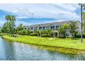 Exterior of condo buildings facing a pond, with manicured lawns and mature palms at 8827 Manor Loop # 208, Lakewood Ranch, FL 34202