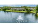 Scenic lake view showcases a fountain, lush greenery, and tropical palm trees at 8827 Manor Loop # 208, Lakewood Ranch, FL 34202