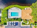 Aerial view of community pool area with lounge chairs, lush landscaping, and nearby parking at 1000 San Lino Cir # 1032, Venice, FL 34292