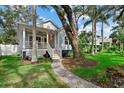 Inviting home with a landscaped front yard, a walkway to a yellow door, and a charming front porch at 112 17Th E St, Bradenton, FL 34208