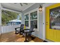 Inviting front porch with rocking chairs, a pendant light, and a bright yellow front door at 112 17Th E St, Bradenton, FL 34208