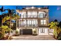 Beautiful beach house at twilight, featuring a spiral staircase and illuminated balconies at 119 Avenida Messina, Sarasota, FL 34242