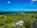 Aerial view of neighborhood with waterfront views, lush landscape, and clear blue skies at 1230 Bayshore Dr, Terra Ceia, FL 34250