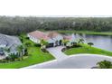 Aerial view features the front of the home with beautiful landscaping, pond view, and paver driveway at 16038 39Th E Gln, Parrish, FL 34219