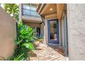 Charming courtyard entrance featuring a blue door, brick pathway, and lush tropical plants for a welcoming ambiance at 200 Cocoanut Ave # 1, Sarasota, FL 34236