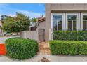 Brick pathway leading to a secure metal gate, offering a private entrance with lush green hedges and garden wall at 200 Cocoanut Ave # 1, Sarasota, FL 34236