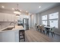Bright kitchen with stainless steel appliances, white cabinetry, and adjacent dining area at 2400 Ezzell Ct, Sarasota, FL 34237