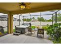 Relaxing screened-in patio with a spa, comfortable seating, and serene backyard views at 2450 Dovesong Trace Dr, Ruskin, FL 33570