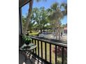 Scenic view from the balcony showcasing lush greenery, a community pool, and serene landscaping at 3245 Beneva Rd # 203, Sarasota, FL 34232