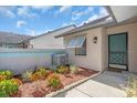 Inviting front entrance of home with tidy flower bed, window, and light fixture on the exterior wall at 327 40Th W Ct, Palmetto, FL 34221